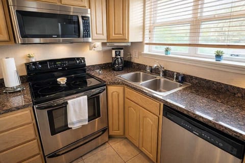 Modern Kitchen with Stainless Steel Appliances, Granite Counters, Coffee Maker, and Natural Light—Perfect for Cooking and Relaxing During Your Stay