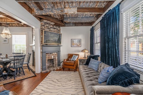 Experience timeless elegance with a historic Haint blue ceiling and luxurious decor. Above the fireplace, a Samsung Frame TV blends art and technology, offering the latest streaming apps and Samsung Plus for endless entertainment in this beautifully design