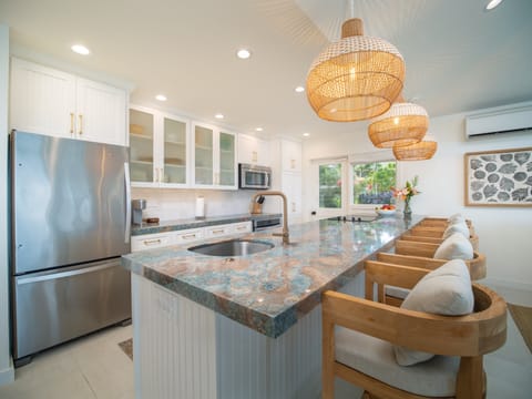 Gourmet kitchen with island seating, fully equipped for preparing meals and entertaining in your Maui retreat.