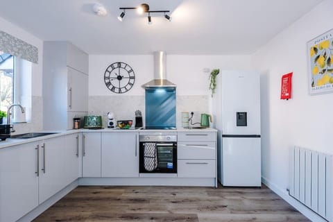 The kitchen is fully equipped with modern appliances, including a coffee machine, making it a perfect space for preparing meals and enjoying your morning brew. It offers ample counter space and storage, ideal for both cooking and casual dining.
