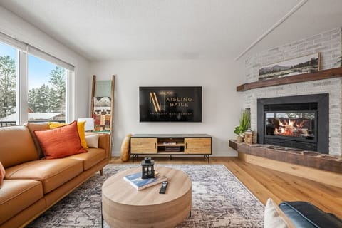 Living room with a smart TV, gas fireplace, board games & cozy seating options.