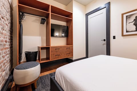 Bedroom 1 - Closet space equipped with hangers, laundry hamper, and iron with ironing board.