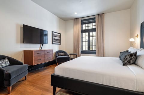 Bedroom 1 - King bed featuring a built-in wardrobe, flat-screen TV, and additional seating.