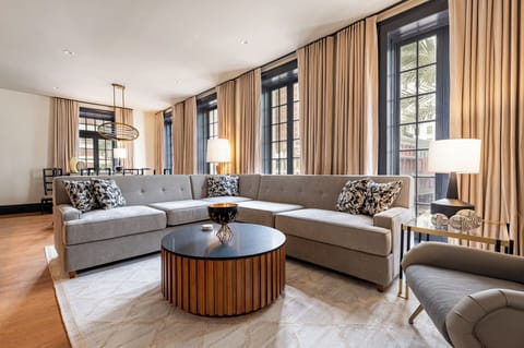 Stylish living area featuring charming windows that flood the space with natural light and offer captivating views of Canal Street.