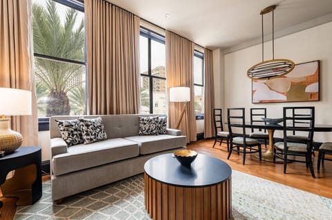 Elegant living space overlooking Canal Street, framed by tall windows that flood the room with light and offer a vibrant cityscape view.