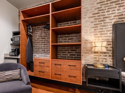 Bedroom 4 - Closet space equipped with hangers, laundry hamper, iron with ironing board, coffee station, mini-fridge, and microwave.