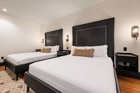 Bedroom 1 - Double queen beds featuring a built-in wardrobe and flat-screen TV.