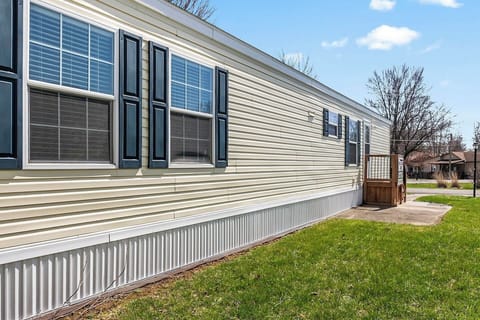 Side view highlighting the home’s length, multiple windows, and private entry steps.