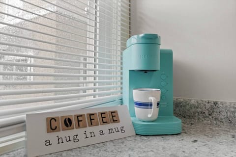 Charming full kitchen featuring a coffee maker alongside motivational quotes for coffee lovers, creating an inspiring atmosphere. Perfectly designed for brewing your favorite cup, blending style and functionality for an uplifting kitchen experience