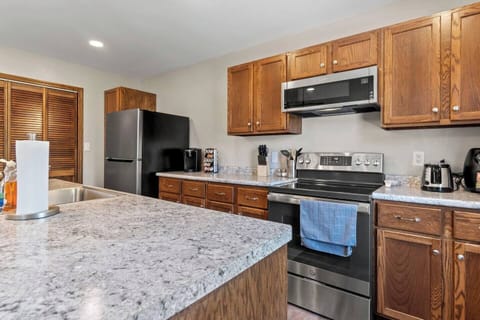 Kitchen showcasing sleek modern appliances, including a stove, fridge, and microwave, designed for both style and functionality.