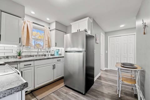 Compact kitchen with a fridge and a cozy dining area for two, perfect for intimate meals.