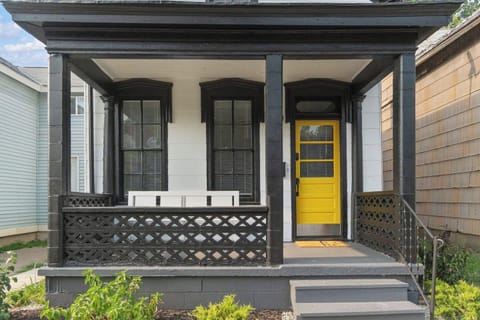 Front porch with a vibrant yellow door, adding a cheerful and welcoming touch to the entrance, surrounded by well-maintained landscaping.