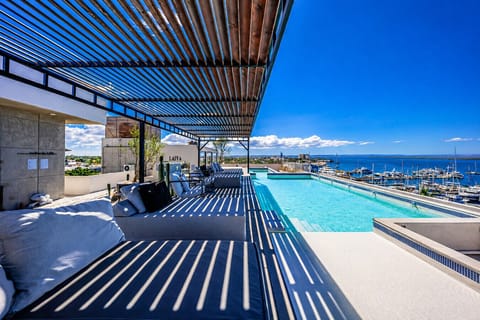Terraza rooftop espectacular con alberca privada y vistas panorámicas a la marina y al Mar de Cortés. Disfruta de un ambiente moderno y relajado, con cómodos lounges bajo pérgola, sombras naturales y una increíble combinación de tonos azules que hacen de 