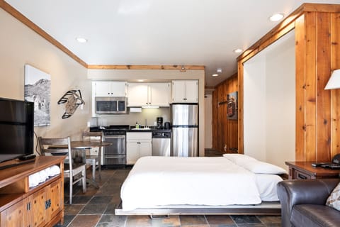 Compact and stylish Park City studio featuring a full kitchen, dining space, and rustic wood accents—ideal for couples or solo travelers