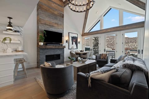 Living Room: Soaring windows, view over main street, couch,2 chairs, 55” Smart TV, gas fireplace, 6-person dining table
