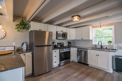 Stainless steel appliances, including an oven, refrigerator, and a spacious cooktop, offer both high performance and aesthetic appeal.