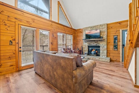 Living room includes a wood-burning fireplace, large Smart TV, and comfortable furniture.
