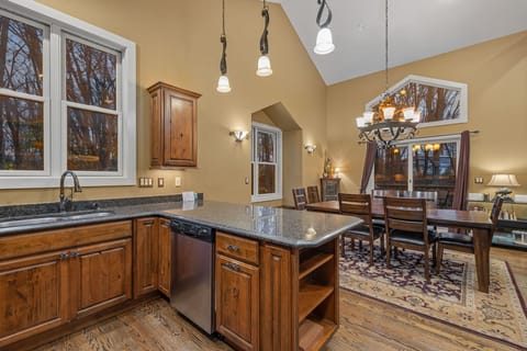 Wide countertops, cozy dining, and forest views—this kitchen is serving up all the heartwarming vibes.