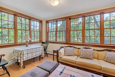 Sun-filled sitting room with wraparound windows and treetop views
