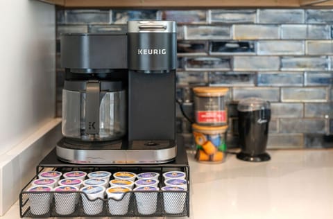 Coffee station w/ modern appliances & tiled backsplash for easy morning routines.