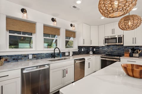 Sleek kitchen w/ stainless appliances, bold backsplash & plenty of prep space.