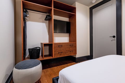Bedroom 1 - Closet space equipped with hangers, laundry hamper, and iron with ironing board.