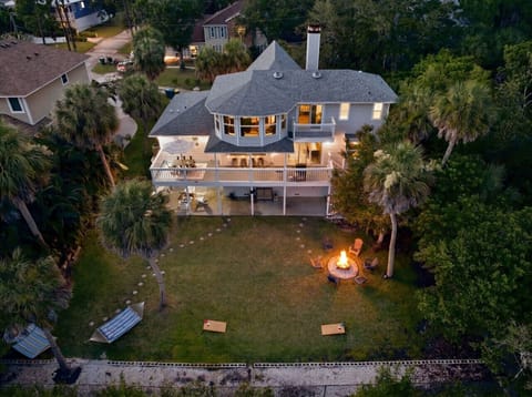 The backyard setup: fire pit, hammocks, lawn games, palms, and plenty of room to unwind.