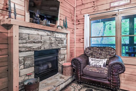 Living Room Retreat: Enjoy a stone fireplace and peaceful views from your comfy leather chair!