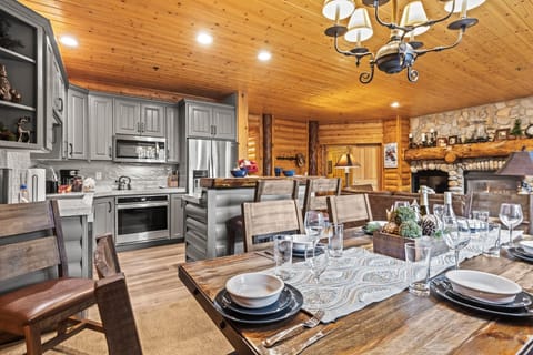 The kitchen blends seamlessly with cozy stone fireplace living space.