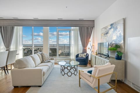 Living room with a Smart TV and floor-to-ceiling windows.