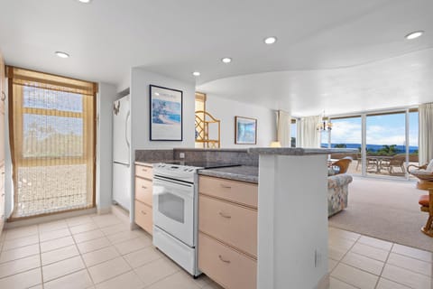 Your kitchen flows seamlessly into an open living space with stunning ocean views, perfect for preparing meals while enjoying the coastal panorama through expansive windows.