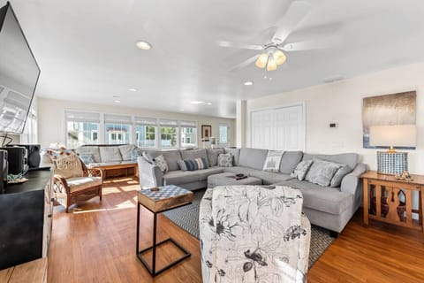 Main living area of game room contains plenty of sitting, 65 inch wall mounted TV with full cable chanels and smart TV apps, as well as music player/sound bar.   checkers, card games, bumper pool, shuffle board and arcade system and access to deck.