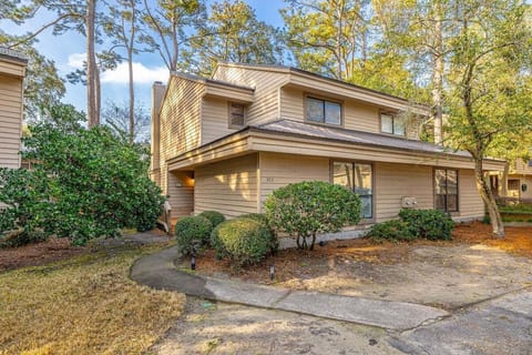 Two-story property exterior with wood siding and landscaping