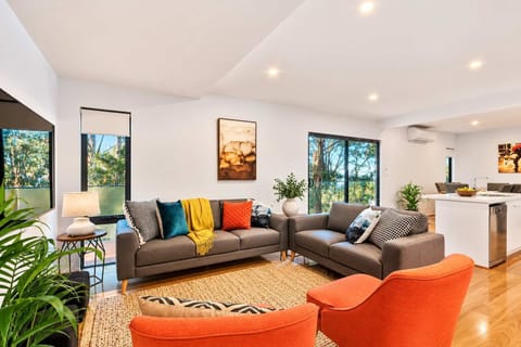 Spacious, light-filled living area with comfortable seating, Smart TV and beautiful bushland outlooks.
