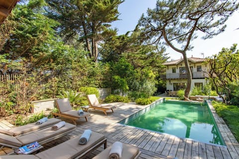 La Piscine et ses transats avec la maison en arrière plan