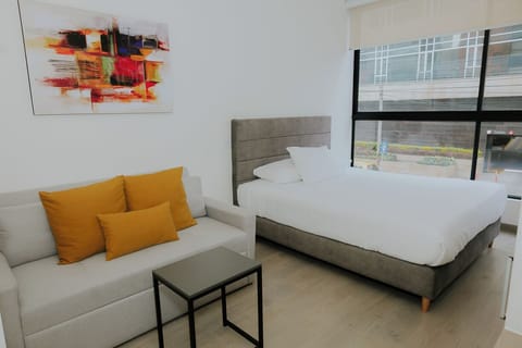 Moderno, luminoso y cómodo espacio con cama doble y sofá acogedor.