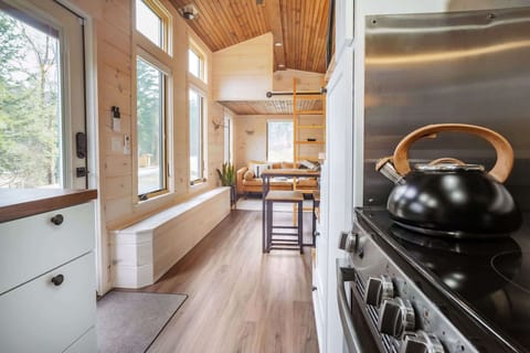 The kitchen with farmhouse sink, butcher block counter tops, full stove / oven and apartment-sized fridge + freezer.
