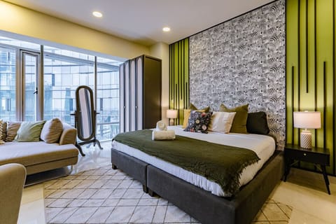 Relax in the chic king-size bed with plush pillows and modern decor.