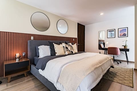 Another perspective of the primary bedroom, highlighting soft bedding, rich textures, and the abundance of natural light.