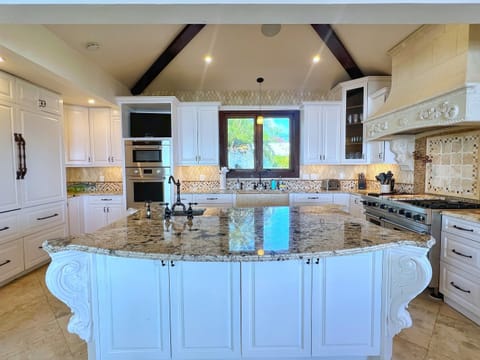 A chef’s kitchen with granite counters and stainless steel appliances awaits.