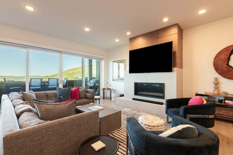 Open-concept living room with gas fireplace and mountain views