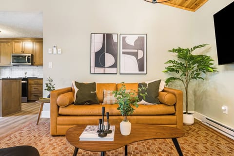 Mid-century living with leather seating, art & open flow—great for gatherings.