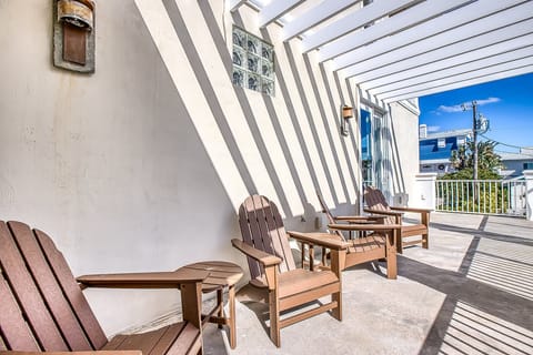The second-floor balcony features Adirondack chairs, perfect for relaxing and soaking up the Florida sun.