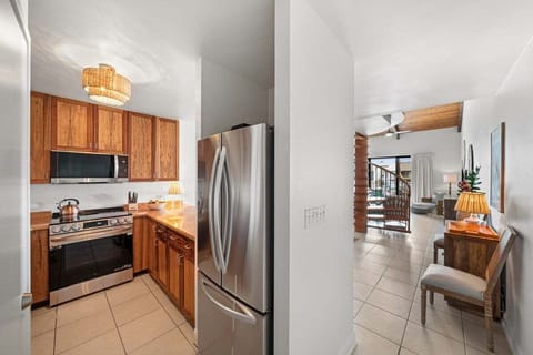 Fully equipped kitchen with stainless steel appliances, warm wood finishes, and a clean, functional layout.