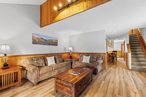 Relax in your spacious living room with soaring ceilings, warm wood accents, and comfortable seating perfect for unwinding after mountain adventures.