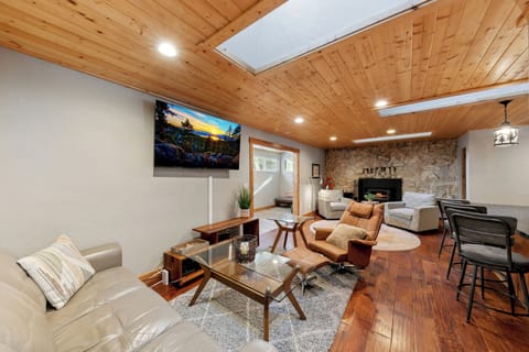 Unwind in your spacious living area with soaring wood ceilings, cozy fireplace, and modern comforts perfect for relaxing after mountain adventures.