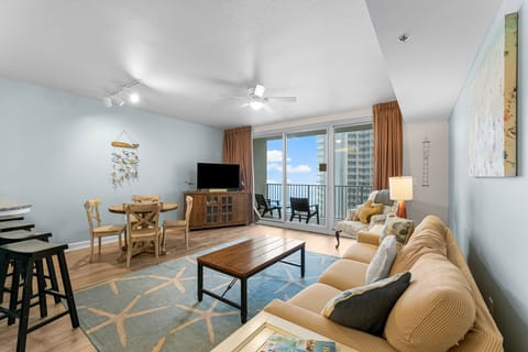 Spacious living room with coastal decor and balcony access for relaxing views.