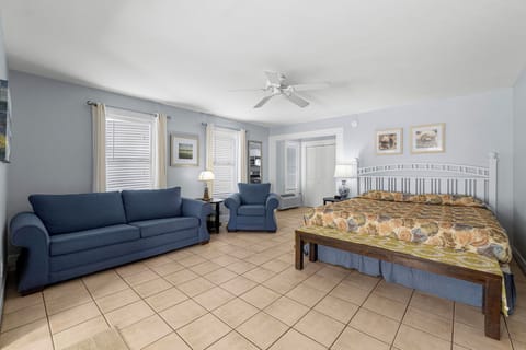 Spacious bedroom with a seating area and natural light from multiple windows