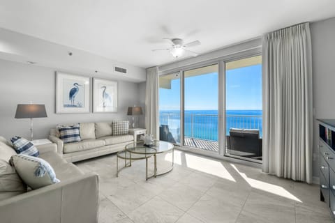 Bright, airy living room w/ floor-to-ceiling windows framing stunning beachfront views.