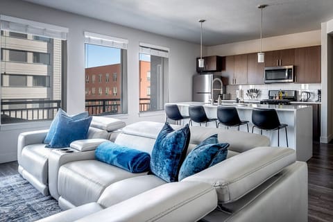 Beautifully designed living room. 75` TV, leather sofa and amazing views of mountains and city skyline.